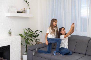 Çocuklar evde cep telefonuyla oynuyorlar. Yüksek kalite fotoğraf