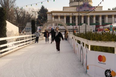 KYIV, UKRAINE - 23 Aralık 2022: buz pateni insanları. İnsanlar buz pateni sahasında eğleniyor. Kyiv 'de yeni yıl tatili. Kyiv Noel ve Yeni Yıl dekorasyonları