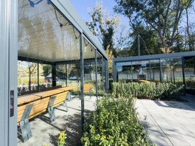 İçinde doğal malzemelerden yapılmış geniş bir barbekü alanı var. Çatılı bir yapının altında, masa ve sandalyeli bir teras. - Evet. Yüksek kalite fotoğraf