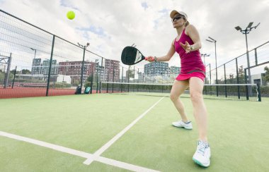 Padel tenisinde Avrupalı genç bayan tenisçi dışarıda oynanan dostça çiftler maçında oynuyor. Yüksek kalite fotoğraf