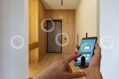 Akıllı ev, ev otomasyonu, uygulama simgeli aygıt. Kadın akıllı telefonunu akıllı güvenlik uygulaması ile evinin kapısını açmak için kullanıyor.