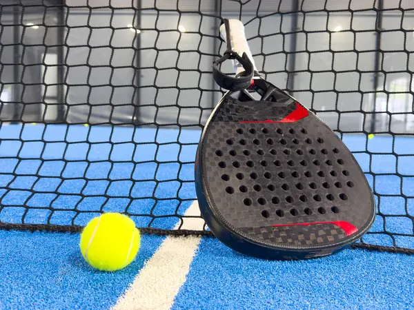 Padel raketi mavi bir kortta top ile. Yüksek kalite fotoğraf