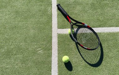 Tenis raketi ve yeşil çimen topunun en üst görüntüsü. Yatay spor posteri, tebrik kartları, başlıklar, web sitesi. Yüksek kalite fotoğraf