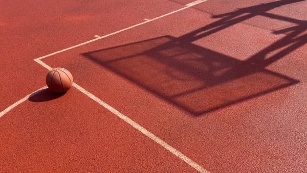 Lastik spor sahasında duran basketbol için en iyi turuncu top. Bahçede spor kırmızı zemin. Yüksek kalite fotoğraf