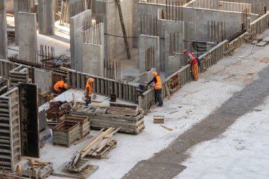 İnşaat işçisi Beton inşaat şantiyesindeki ticari beton döşemeler ve inşaat mühendisi veya inşaat mühendisi müfettişliği müfettişliği sırasında dökülüyor. Yüksek kalite fotoğraf