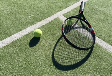 Sahada sarı bir tenis topu ve tenis raketi yatıyor. Yüksek kalite fotoğraf