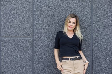 Binanın yanında duran genç, sevimli sarışın. Yüksek kalite fotoğraf