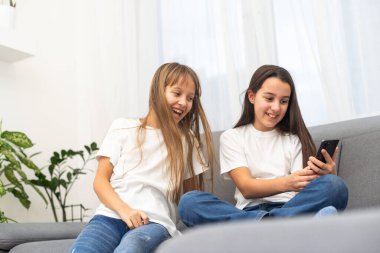 Çocuklar evde cep telefonuyla oynuyorlar. Yüksek kalite fotoğraf