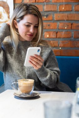 Kafede tek başına kahve içen genç bir kadın. Yüksek kalite fotoğraf