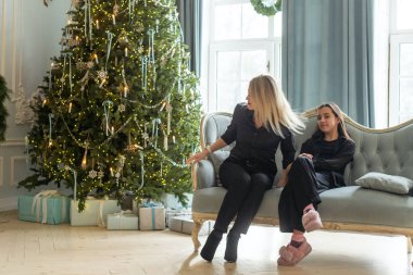 Mutlu Kafkasyalı anne ve kızı Noel boyunca Noel ağacı süsler ve eğlenirler. Yüksek kalite fotoğraf