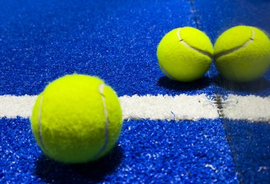 Mavi raket tenis kortunun yanında raket tenis topu. Yüksek kalite fotoğraf