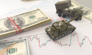 Bir sürü banknotta küçük yeşil bir tank. Savaş finansmanı ya da savunma için para harcamak. Yüksek kalite fotoğraf