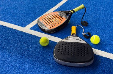 Siyah profesyonel raket tenis raketi ve mavi arka planda doğal ışıklandırmalı top. Yatay spor temalı poster, tebrik kartları, başlıklar, web sitesi ve uygulama. Yüksek kalite fotoğraf