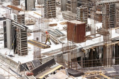 İnşaat işçileri çimento çerçevelerinin montajında işbirliği yapıyorlar. Yüksek kalite fotoğraf