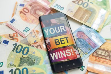 Akıllı telefon ve yakın plan para ile kumar mobil uygulaması. Spor ve bahis konsepti. Yüksek kalite fotoğraf