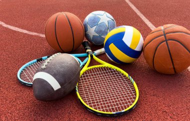 Amerikan futbolu, futbol topu, tenis raketi, tenis topu ve basketbol da dahil olmak üzere çeşitli spor malzemeleri. Yüksek kalite fotoğraf