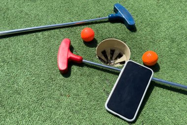 Golf sopaları, akıllı telefon ve suni çimlerde taşakları olan seriler. Yüksek kalite fotoğraf