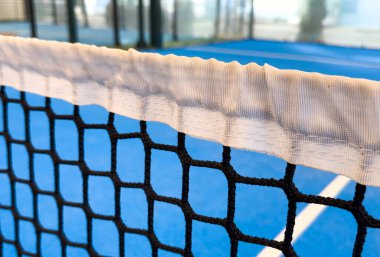  Tenis Net 'li açık hava padel Court. Mavi sahada tenis ağıyla oynanan aktif bir maç ve insan yok. Yüksek kalite fotoğraf