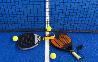 Padel raketi mavi bir kortta top ile. Yüksek kalite fotoğraf