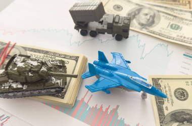 Askeri oyuncak uçak uçak savaş uçağı, ekonomik grafikler ve para. Yüksek kalite fotoğraf