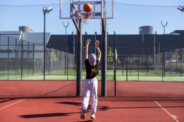 Şehrin arka planında basketbol topu olan bir kız. Sokak basketbolu. Yüksek kalite fotoğraf
