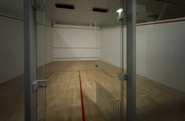 Beyaz duvarları ve cilalı zemini olan squash kortu, motivasyon ve kararlılık konsepti. Yüksek kalite fotoğraf