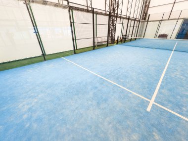 Boş raket tenis kortu, kapalı bir barakanın ışıkları açık ve oyuncuları yok. Yüksek kalite fotoğraf