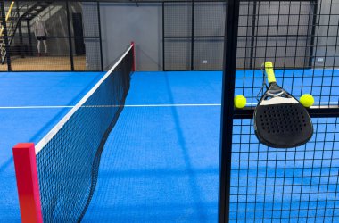 Padel raketi mavi bir kortta top ile. Yüksek kalite fotoğraf