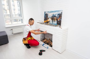 Profesyonel teknisyen odaya elektrikli şömine kuruyor. Yüksek kalite fotoğraf