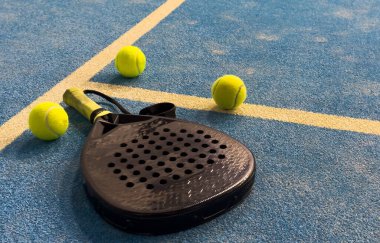 Padel raketi mavi bir kortta top ile. Yüksek kalite fotoğraf