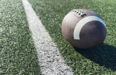 Sahada bir Amerikan futbolu yakın plan, arkada oyuncular. Yüksek kalite fotoğraf