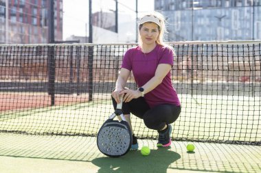 Güneşli bir günde mahkemede Padel oynayan genç bir kadın. Yüksek kalite fotoğraf