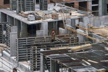 İnşaat işçileri çimento çerçevelerinin montajında işbirliği yapıyorlar. Yüksek kalite fotoğraf