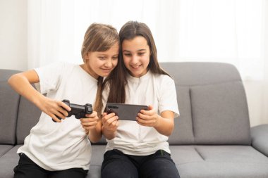 Evde birlikte oyun oynayan iki ortaokul öğrencisi kız. Yüksek kalite fotoğraf