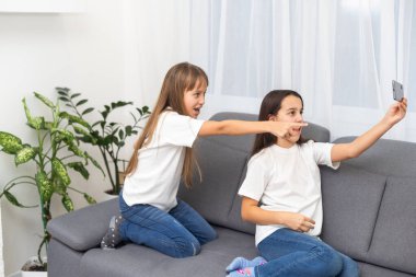 Çocuklar evde cep telefonuyla oynuyorlar. Yüksek kalite fotoğraf