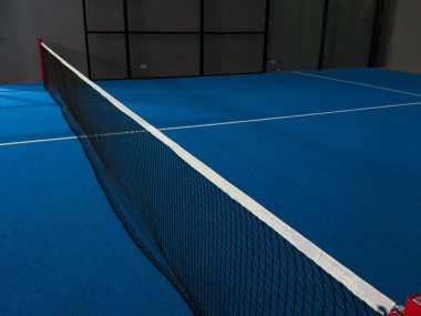  İnternetteki padel Court 'ta. Mavi sahada tenis ağıyla oynanan aktif bir maç ve insan yok. Yüksek kalite fotoğraf