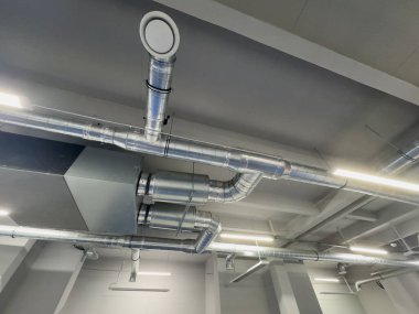 Metal borular endüstriyel bir işletmenin tavanında termal yalıtım yapıyor. Yüksek kalite fotoğraf
