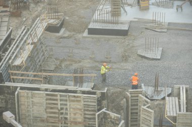  İşçiler büyük inşaat sahalarında çalışıyor ve sanayi yeni inşaat sektöründe birçok vinç çalışıyor. Yüksek kalite fotoğraf