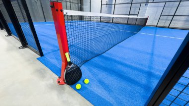 Padel raketi mavi bir kortta top ile. Yüksek kalite fotoğraf