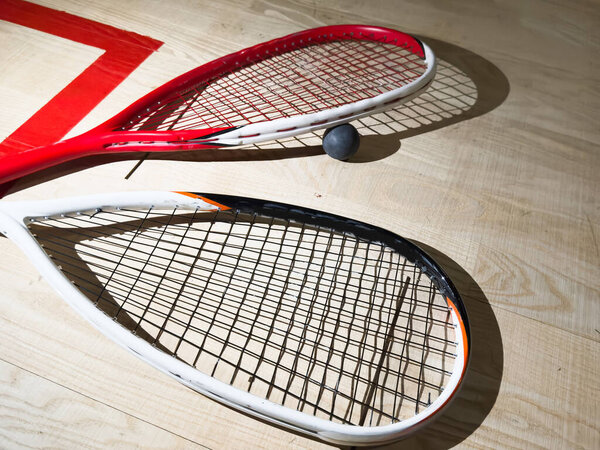 Empty squash court and rackets on the wooden floor. High quality photo