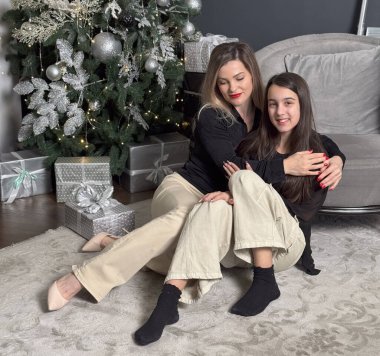 Mutlu bir annenin kızına sarılmasının yakın çekimi, rahat bir evde Noel havası. Yüksek kalite fotoğraf