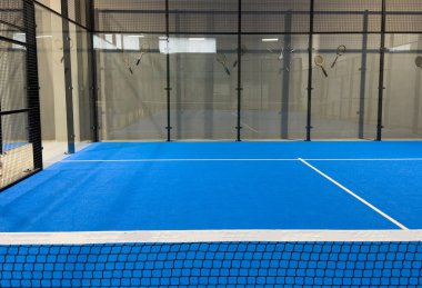  İnternetteki padel Court 'ta. Mavi sahada tenis ağıyla oynanan aktif bir maç ve insan yok. Yüksek kalite fotoğraf