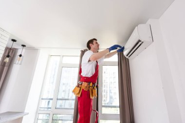 temizlik için klimanın hava filtresini kaldıran teknisyen servisi