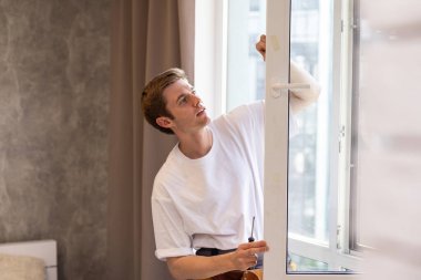 İnşaat işçisi eve pencere kuruyor.