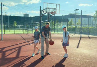 Yaz tatilleri, spor ve insanlar konsepti. Basketbol sahasında top oynayan mutlu aile. Yüksek kalite fotoğraf