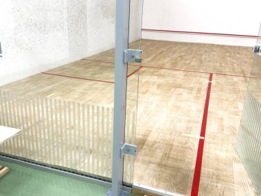 Beyaz duvarları ve cilalı zemini olan modern squash kortu motivasyon ve kararlılık konsepti. Yüksek kalite fotoğraf