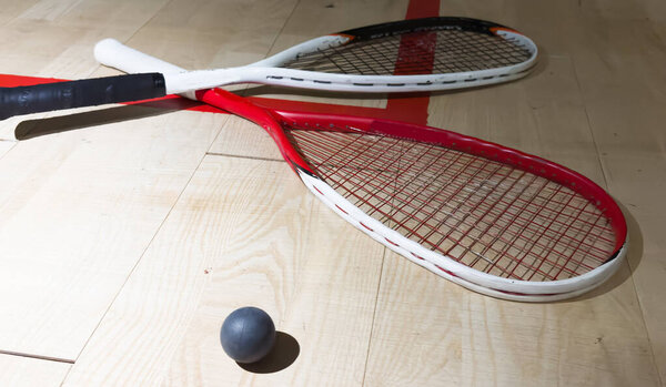 Empty squash court and rackets on the wooden floor. High quality photo