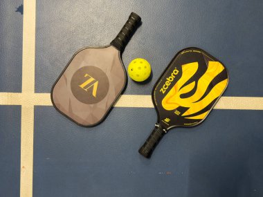 Kyiv, Ukrayna - 14 Aralık 2024 Pickleball tenis raketi sahada. Kopyalama alanı olan mavi arkaplan. Spor sahası ve top. Yüksek kalite fotoğraf