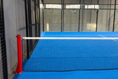  İnternetteki padel Court 'ta. Mavi sahada tenis ağıyla oynanan aktif bir maç ve insan yok. Yüksek kalite fotoğraf