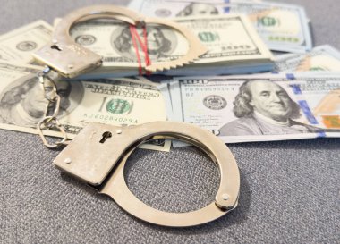 Amerikan doları ve kelepçe, yozlaşma, kirli para ya da finansal suçlar kavramı. Yüksek kalite fotoğraf